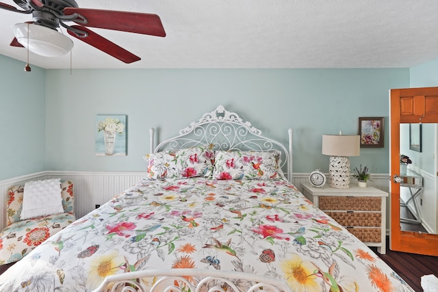 bedroom featuring ceiling fan, a textured ceiling, and hardwood / wood-style flooring