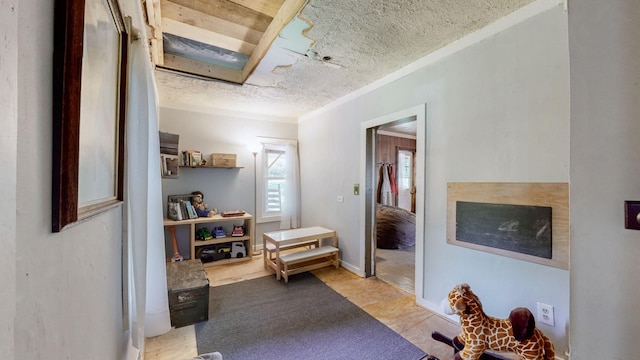 corridor featuring a textured ceiling and crown molding