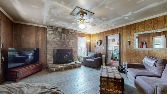 living room featuring wood walls, ceiling fan, and wood-type flooring