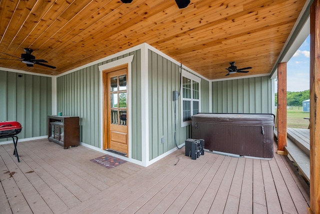 wooden terrace featuring ceiling fan and a hot tub