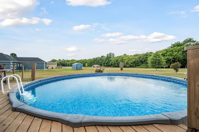 view of pool with a storage unit, a deck, and a yard