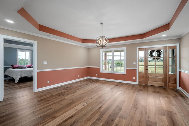 unfurnished dining area with hardwood / wood-style flooring, plenty of natural light, and a raised ceiling