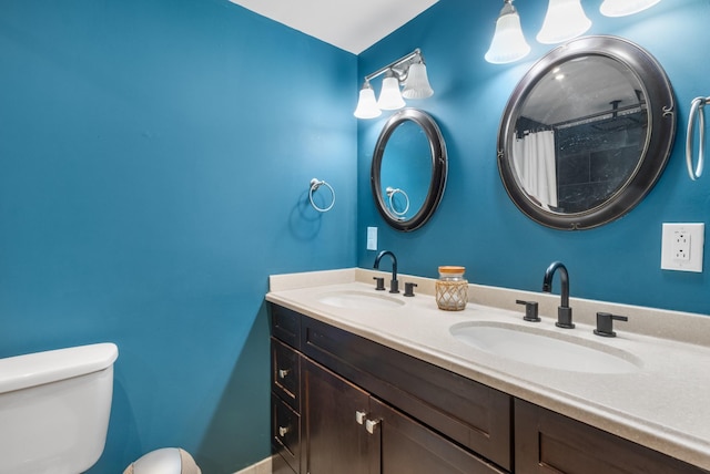 bathroom with toilet, vanity, and curtained shower