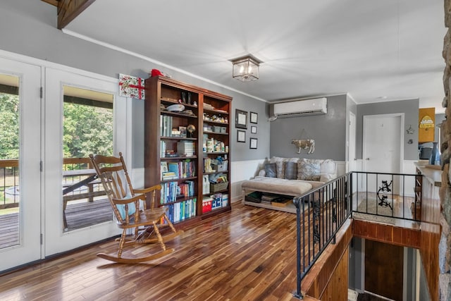 living area with an inviting chandelier, ornamental molding, wood-type flooring, and a wall mounted air conditioner