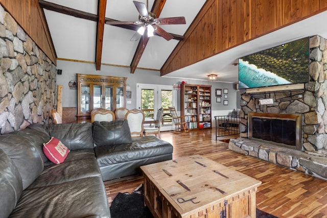 living room featuring ceiling fan, a fireplace, beam ceiling, hardwood / wood-style flooring, and high vaulted ceiling