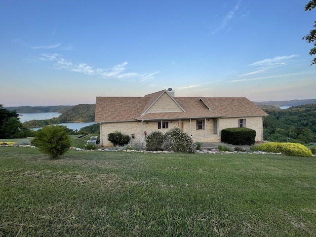 view of front of property featuring a front lawn and a water view