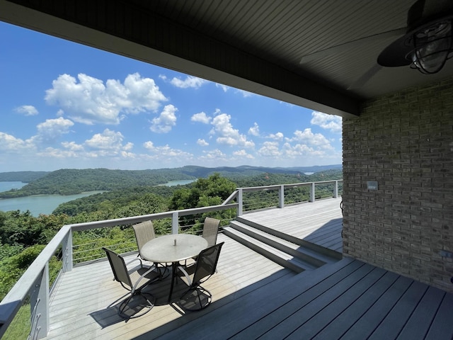 wooden terrace with ceiling fan and a water and mountain view