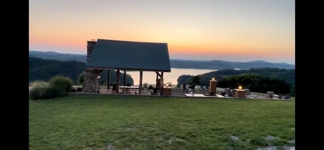 surrounding community with a gazebo, a yard, a mountain view, and a patio