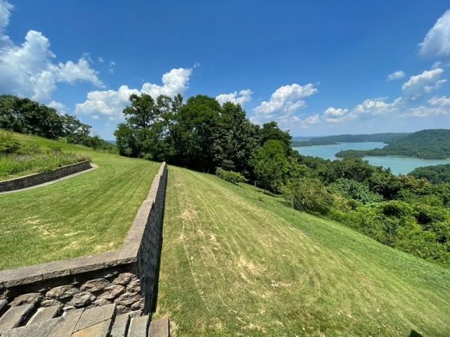 view of property's community with a water view and a lawn