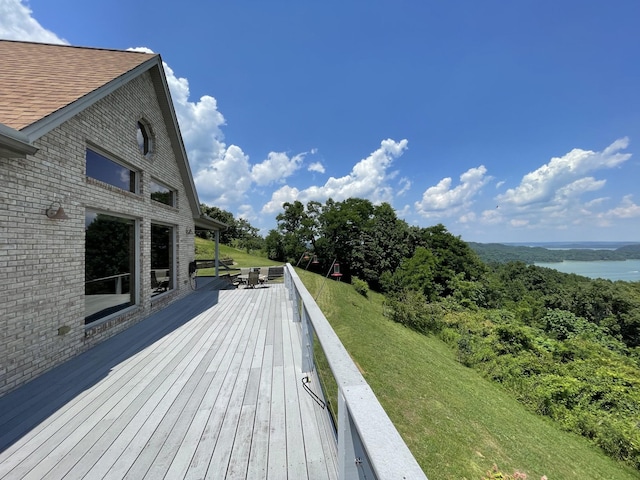 wooden deck with a yard and a water view