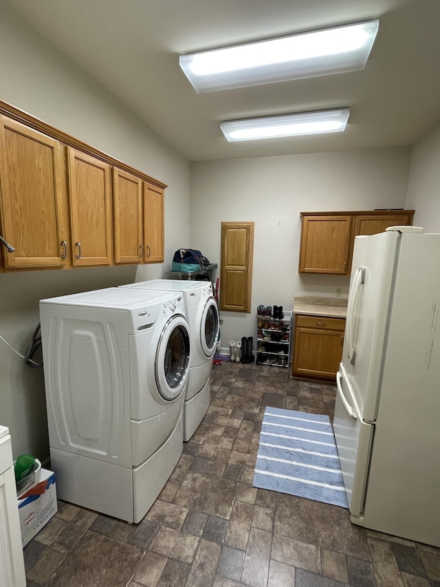 laundry room with stone finish flooring, cabinet space, and washer and clothes dryer