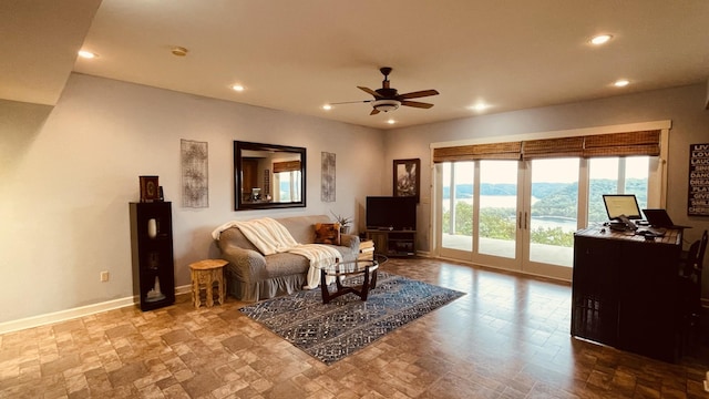 living area with a ceiling fan, recessed lighting, baseboards, and stone finish flooring