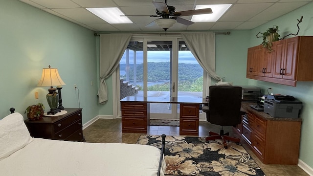 bedroom featuring tile patterned floors, a paneled ceiling, baseboards, and access to outside