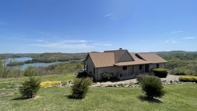 61 Brim Ln, Hilham, TN 38568 - view of front of property featuring a shingled roof, brick siding, a front yard, and a water view