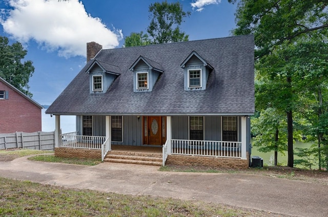 new england style home with central AC unit and covered porch