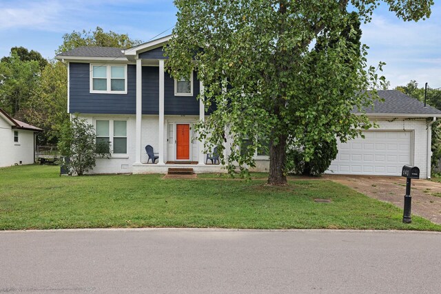 view of front of house featuring a garage, driveway, brick siding, and a front lawn