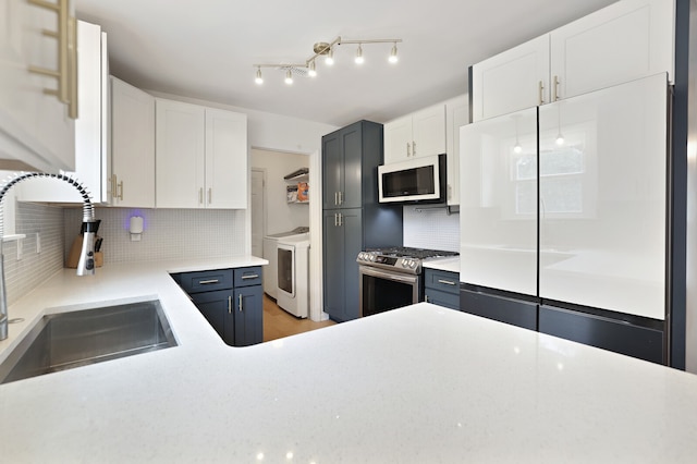 kitchen with sink, white cabinets, refrigerator, and gas stove