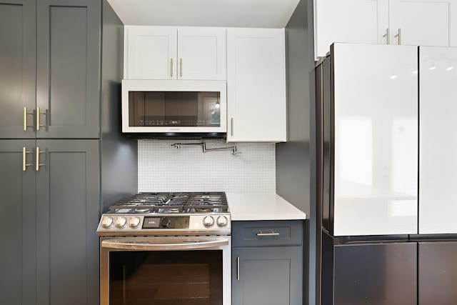 kitchen with decorative backsplash, white cabinetry, gray cabinetry, and stainless steel appliances