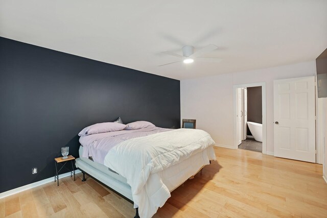 bedroom with an accent wall, light wood finished floors, a ceiling fan, and baseboards