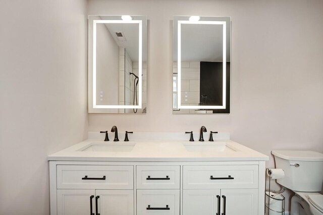 full bath featuring visible vents, a sink, toilet, and double vanity