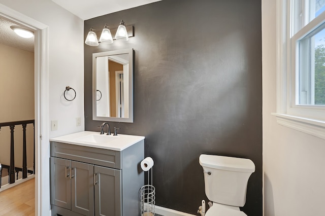 bathroom with toilet, hardwood / wood-style flooring, and vanity