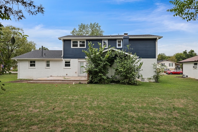 rear view of property featuring a lawn