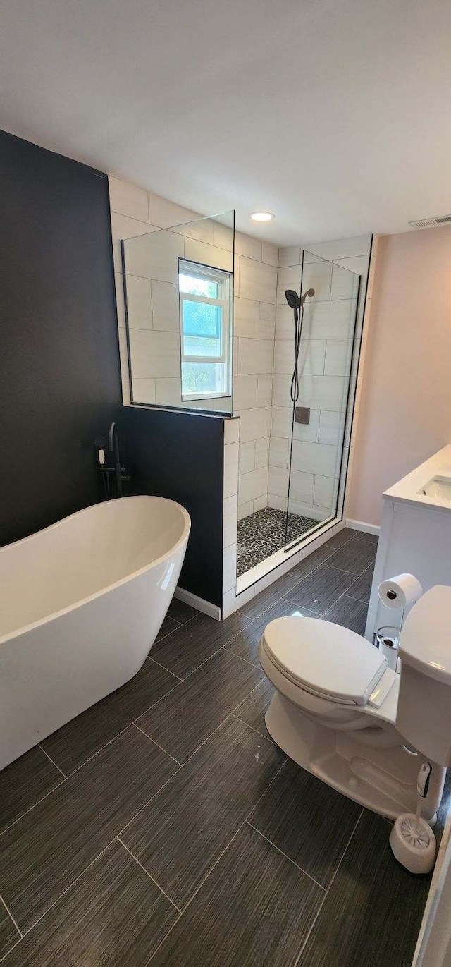 full bathroom featuring toilet, vanity, and separate shower and tub