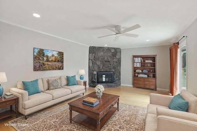 living area with ornamental molding, light wood-type flooring, and a fireplace