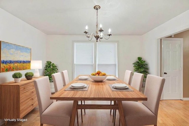 dining space with a notable chandelier and light wood-type flooring