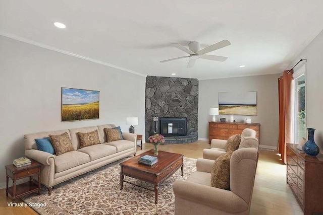 living room featuring crown molding, light hardwood / wood-style flooring, a fireplace, and ceiling fan