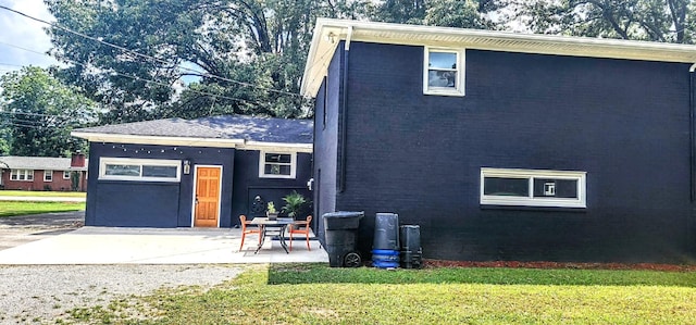 view of side of property featuring a yard and a patio