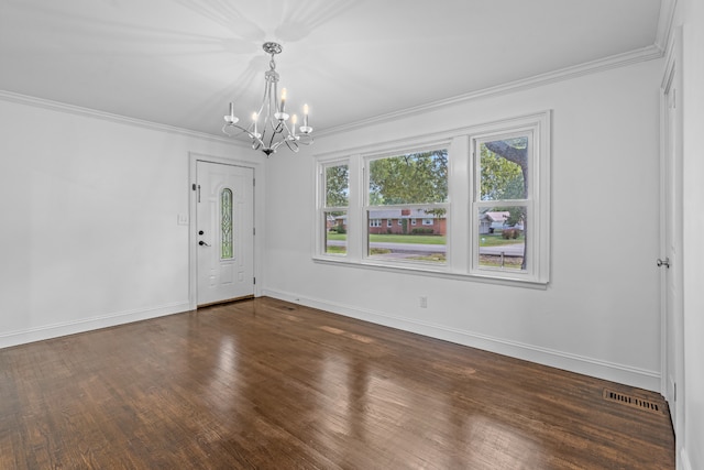 empty room featuring crown molding, dark hardwood / wood-style floors, and a notable chandelier