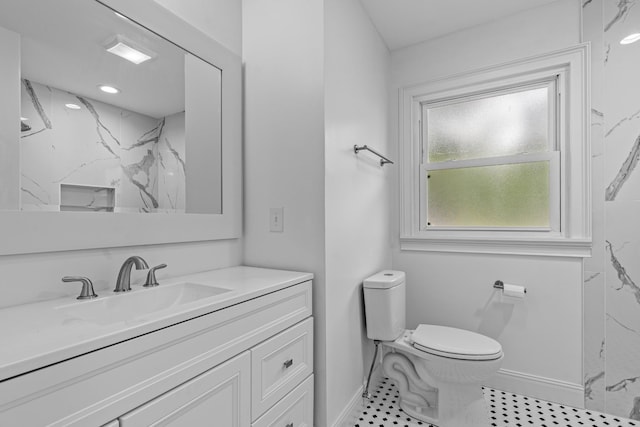 full bathroom featuring a marble finish shower, baseboards, vanity, and toilet