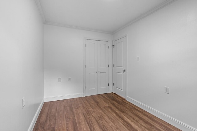 unfurnished room featuring crown molding and dark wood-type flooring