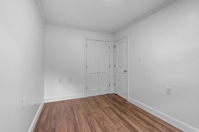 unfurnished room with crown molding, baseboards, and wood finished floors