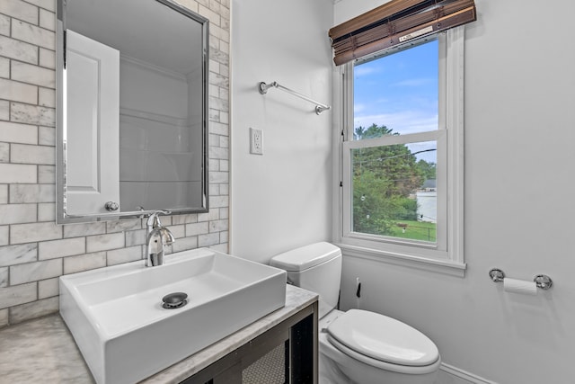 bathroom with vanity, backsplash, and toilet