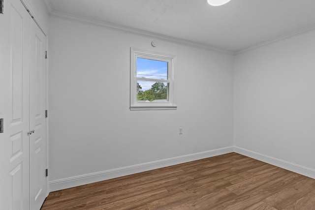 unfurnished bedroom featuring ornamental molding, a closet, baseboards, and wood finished floors