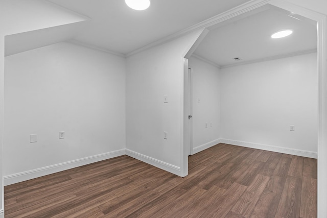 additional living space featuring arched walkways, dark wood-type flooring, lofted ceiling, and baseboards