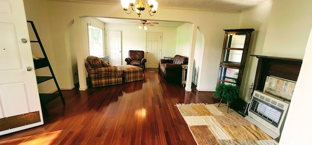 living room featuring ceiling fan with notable chandelier, ornamental molding, and hardwood / wood-style flooring