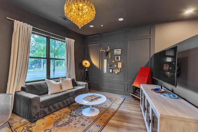 living room featuring a chandelier and light hardwood / wood-style floors