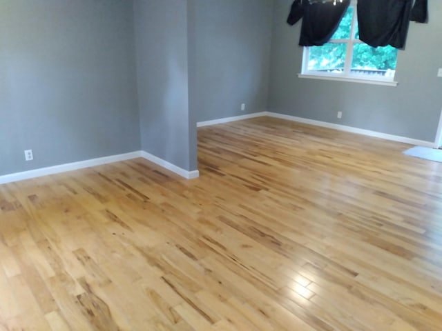 spare room featuring light wood-style floors and baseboards