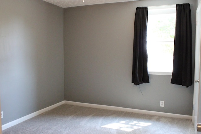 carpeted empty room with baseboards