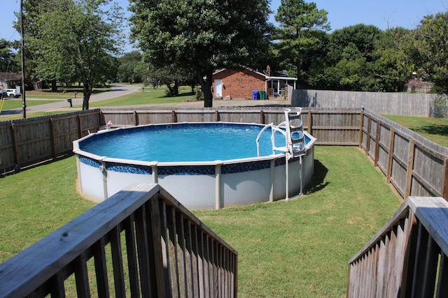 view of pool with a lawn, a fenced backyard, and a fenced in pool