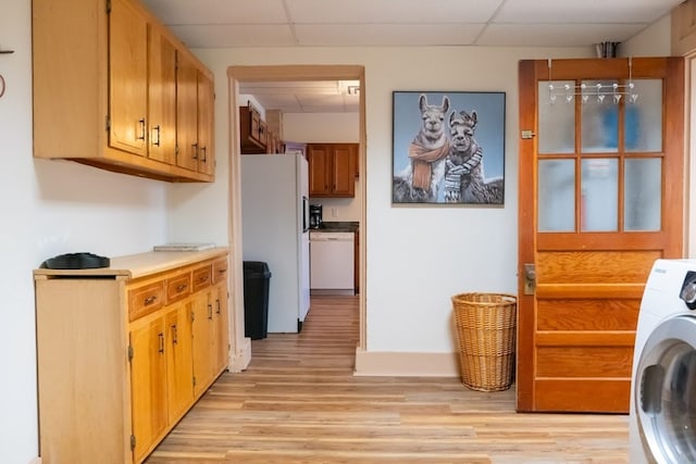 kitchen featuring washer / dryer, light hardwood / wood-style flooring, white appliances, and a paneled ceiling