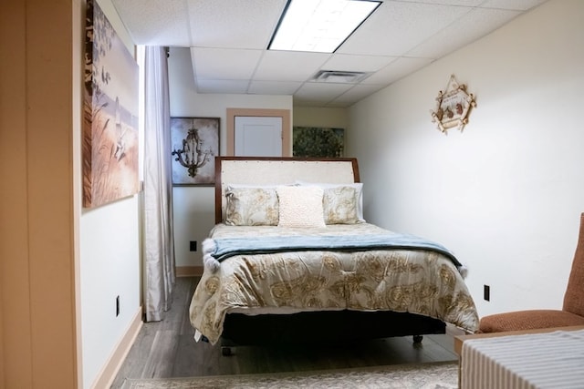 bedroom featuring a paneled ceiling and wood-type flooring