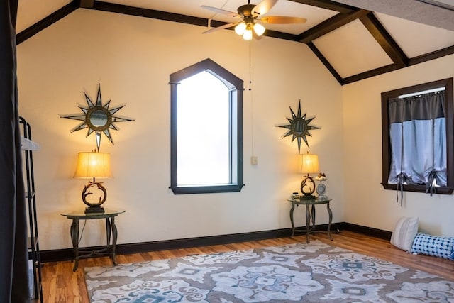 interior space with wood-type flooring, lofted ceiling with beams, and ceiling fan