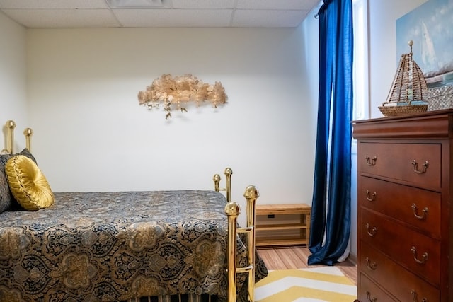 bedroom with light wood-type flooring and a paneled ceiling