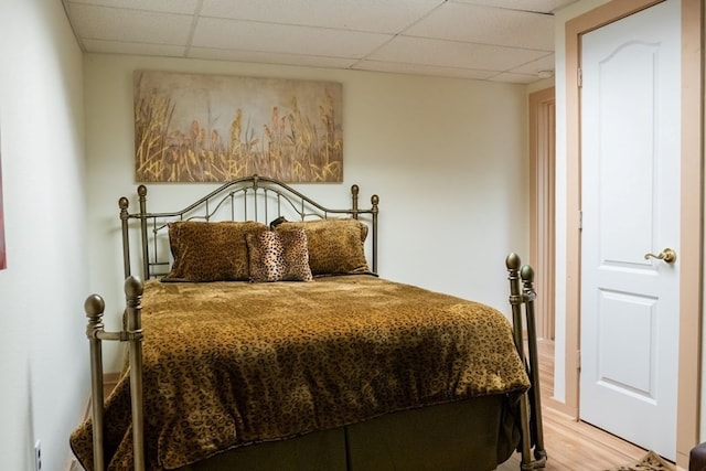 bedroom featuring hardwood / wood-style floors and a paneled ceiling