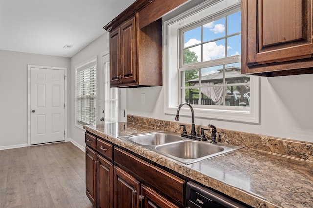 kitchen with sink, a healthy amount of sunlight, light wood-type flooring, and dark brown cabinetry