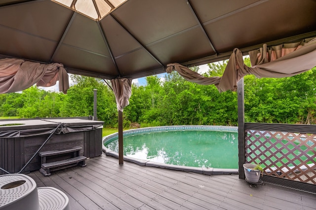 view of pool featuring a deck, a hot tub, and a gazebo